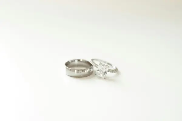 Two wedding rings resting on a plain white table